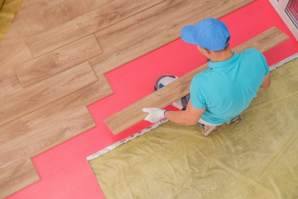 Wooden Floor Panels Installer. Caucasian Remodeling Worker in His 30s Installing New Floor.